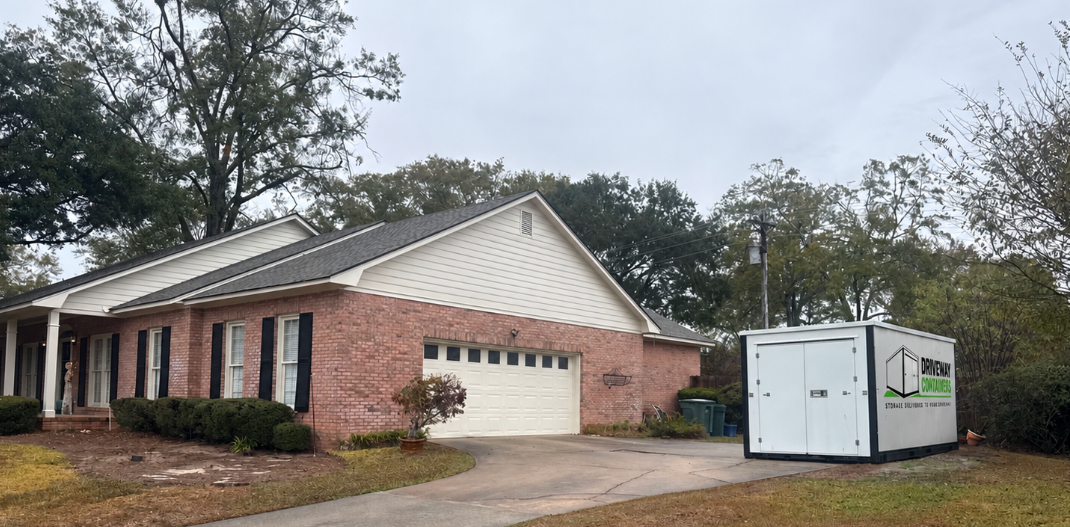 Driveway Containers portable storage unit beside a brick home and garage